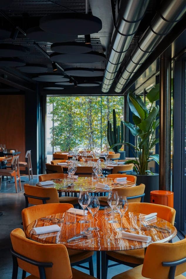 Sala del ristorante con i tavoli apparecchiati e i calici da vino